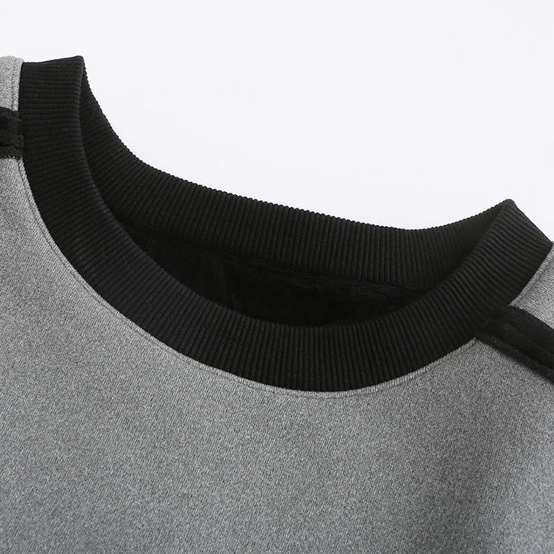 Close-up of a gray sweater with a black neckline on a light gray background