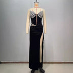Black evening gown with floral embellishments on a mannequin against a gray background