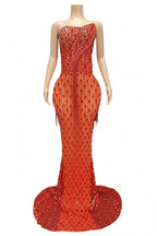 Red beaded evening gown on a mannequin against a dark background