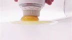 Egg separator being used to separate egg yolks from whites on a white background