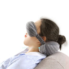 Person using a gray neck pillow with a close-up of a spine illustration on a white background