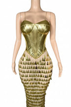Gold mermaid tail dress on a mannequin against a white background