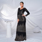 Woman in a black and silver dress posing against a white draped background