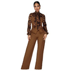 A woman modeling a two-piece brown suit featuring a leopard-print long-sleeve blouse with a high neck and matching wide-leg trousers, set against a plain white background.