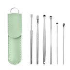 Set of metal ear cleaning tools with a green case on a white background
