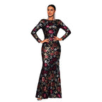Woman wearing a black floral long-sleeve gown on a white background