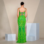 Woman wearing a green evening gown with geometric pattern in a minimalistic setting