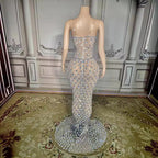 Mannequin wearing a sparkling evening gown in a room with decorative walls and carpet.