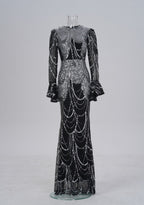 Black and silver sequin evening gown on a mannequin against a white background