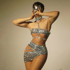 Person wearing a sparkling silver outfit with a neutral background