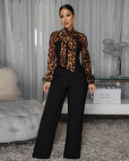 Woman wearing a leopard print top and black pants in an indoor setting.