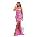 Woman wearing a pink strapless dress with floral patterns on a white background
