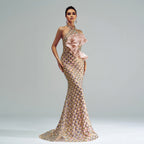 Elegant evening gown with intricate design and pink bow on a plain background