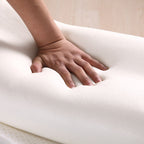 Hand pressing into a soft, white mattress to demonstrate its comfort and support.