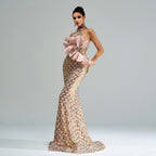 Woman wearing a glamorous evening gown with a large bow on a plain background