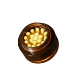 Jar of cream with yellow balls inside, on a beige background
