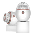 White and rose gold facial cleansing device on a white background