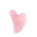 Pink jade gua sha tool with measurements on a white background
