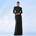 Woman wearing a black sequin gown against a light blue background