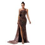 Woman wearing a leopard print evening gown with a high slit on a plain background