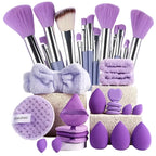 Makeup brushes, sponges, and a towel on a light purple background