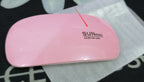 Pink UV/LED nail lamp with 'SUN mini' branding on a black and white patterned surface.