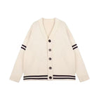 An off-white knit cardigan sweater with black double stripes on the cuffs and hem, featuring a button-up front.