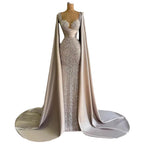 Elegant evening gown with a cape on a mannequin against a white background