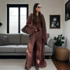 Woman in a brown outfit standing in a modern living room.