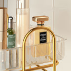Gold Chanel perfume bottle on a decorative shelf with a white background