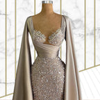 Elegant gown with embellishments on a mannequin against a marble background