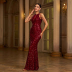 Woman in a red sequin gown standing in an elegant interior setting