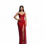 Woman in a red strapless gown with floral embellishments against a white curtain background.