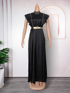 Black evening gown with a belt on a mannequin against a white wall.