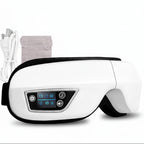 White eye massager with control panel, USB cable, and packaging on a white background