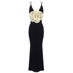 Black evening gown with a large white flower on a white background