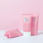 Pink sunscreen lotion with text highlighting features on a white background