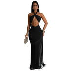 Woman wearing a black evening gown with a deep neckline and fringe details on a white background