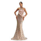 Woman wearing a glamorous evening gown with a large bow on a gray background