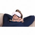 Person wearing a white sleep mask with text about automatic music playback on a light gray background