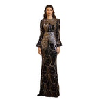 Woman in a black and gold sequin dress standing on a staircase