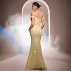 Woman in a yellow evening gown standing in front of an arch with smoke effects.