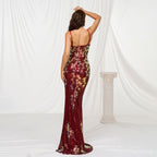 Woman wearing a floral evening gown against a white curtain backdrop