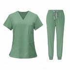 Green medical uniform set with top and pants on a white background