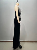 Black evening gown on a mannequin against a plain background
