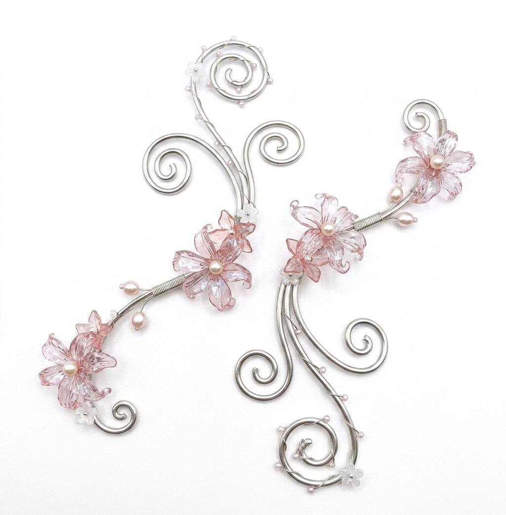 A pair of silver-toned hair claw clips decorated with pink glass flowers and small pearl-like beads, shown on a plain white background.