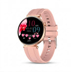 A round smartwatch with a light pink silicone strap and a rose gold-toned case, shown on a clean white background. The watch face is active with a digital display showing the time as 10 AM, a pink flower graphic, and various heart icons.