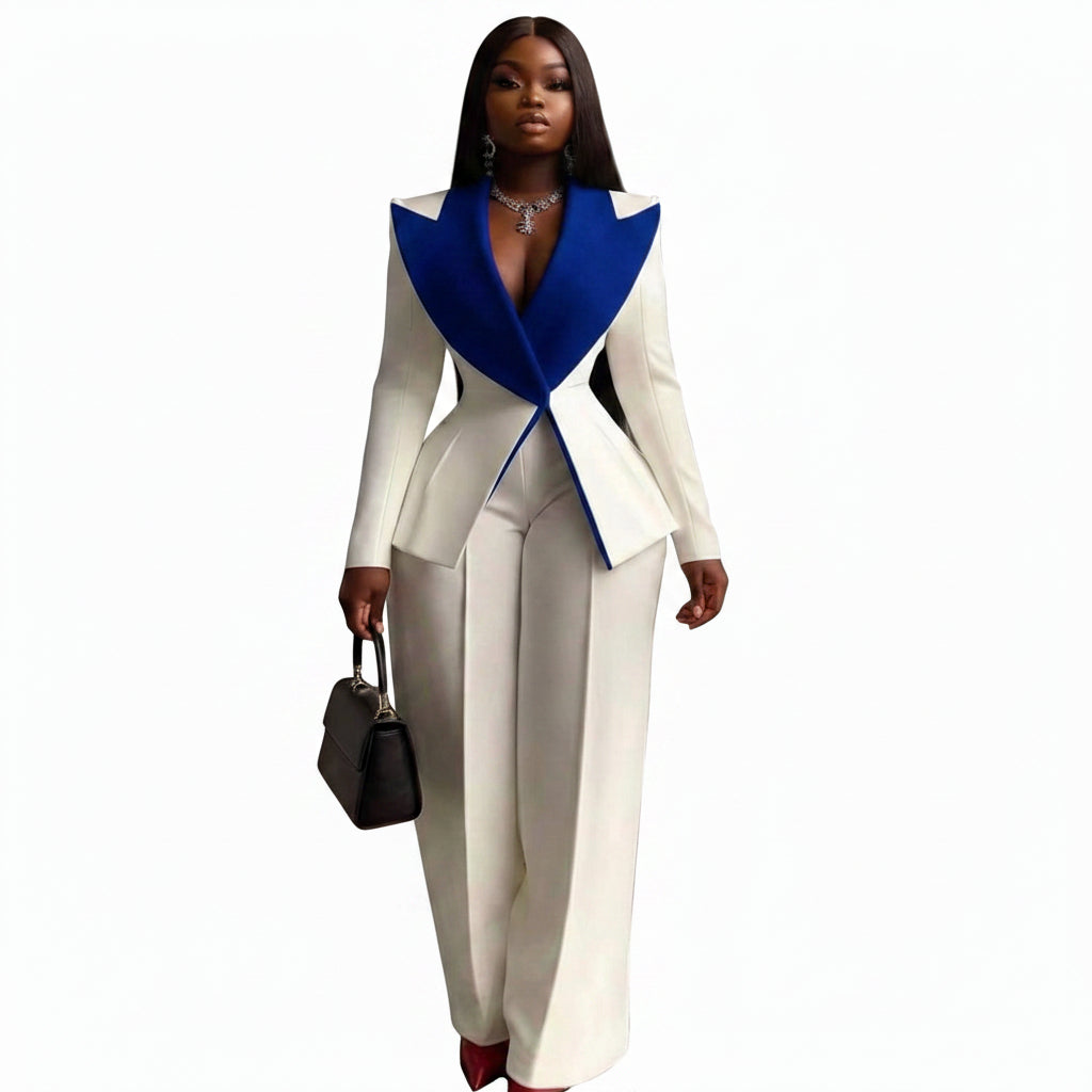 A woman modeling a two-piece cream and royal blue tailored suit with a structured peplum-style top and wide-leg trousers, shown against a plain white background.