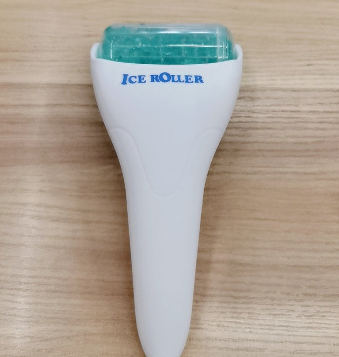 Ice roller with a white handle and green top on a wooden surface