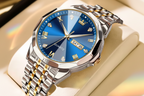 Olevs quartz wristwatch with a blue sunburst dial, silver and gold-tone metal case and link bracelet, shown on a beige display cushion. The red Olevs logo appears in the top-left corner.